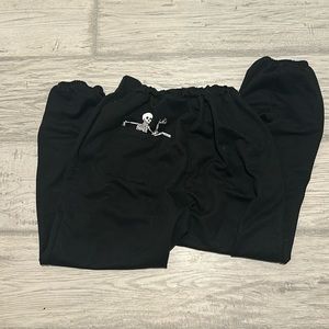 Skeleton in pocket black sweatpants, size small